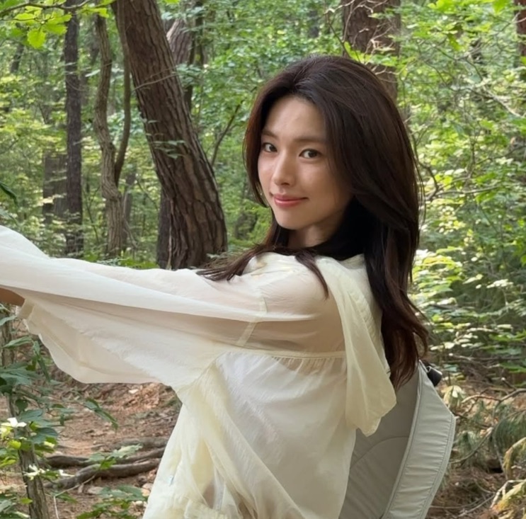 Ha Young num bosque, com os braços abertos