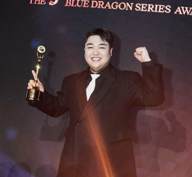 Kim Kyu-won segurando o troféu no Blue Dragon Series Awards