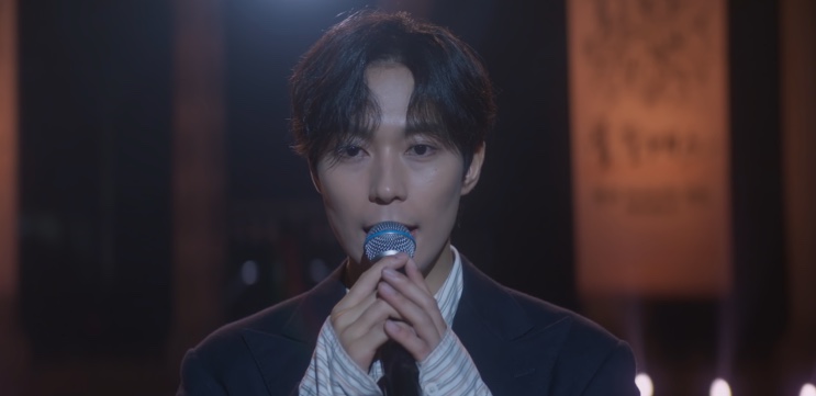 Lee Chan cantando no microfone